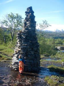 Girl in front of big cairn