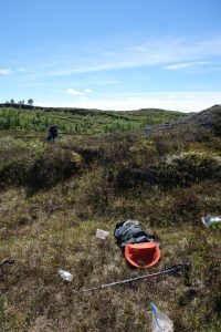 Vanishing hikers near some scattered items in the countryside.