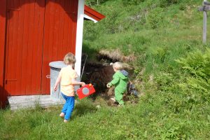 Kinder vor der Hütte, mit Radio in der Hand.