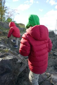 Entdecker-Kinder mit warmen Winterjacken (auch ohne Schnee) draußen unterwegs